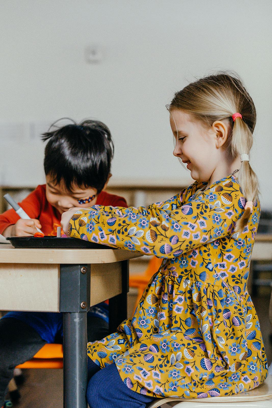 Two children drawing at a table