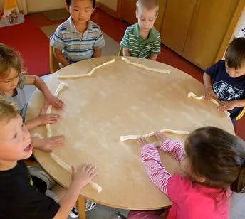 Children playing with dough at a round table