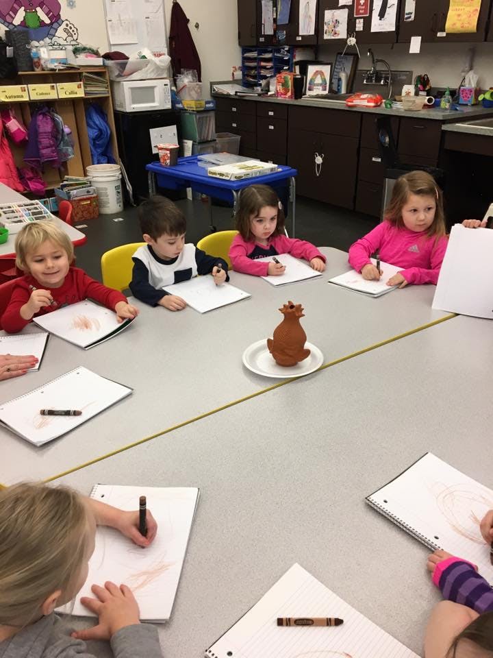 Children drawing at a table in a classroom