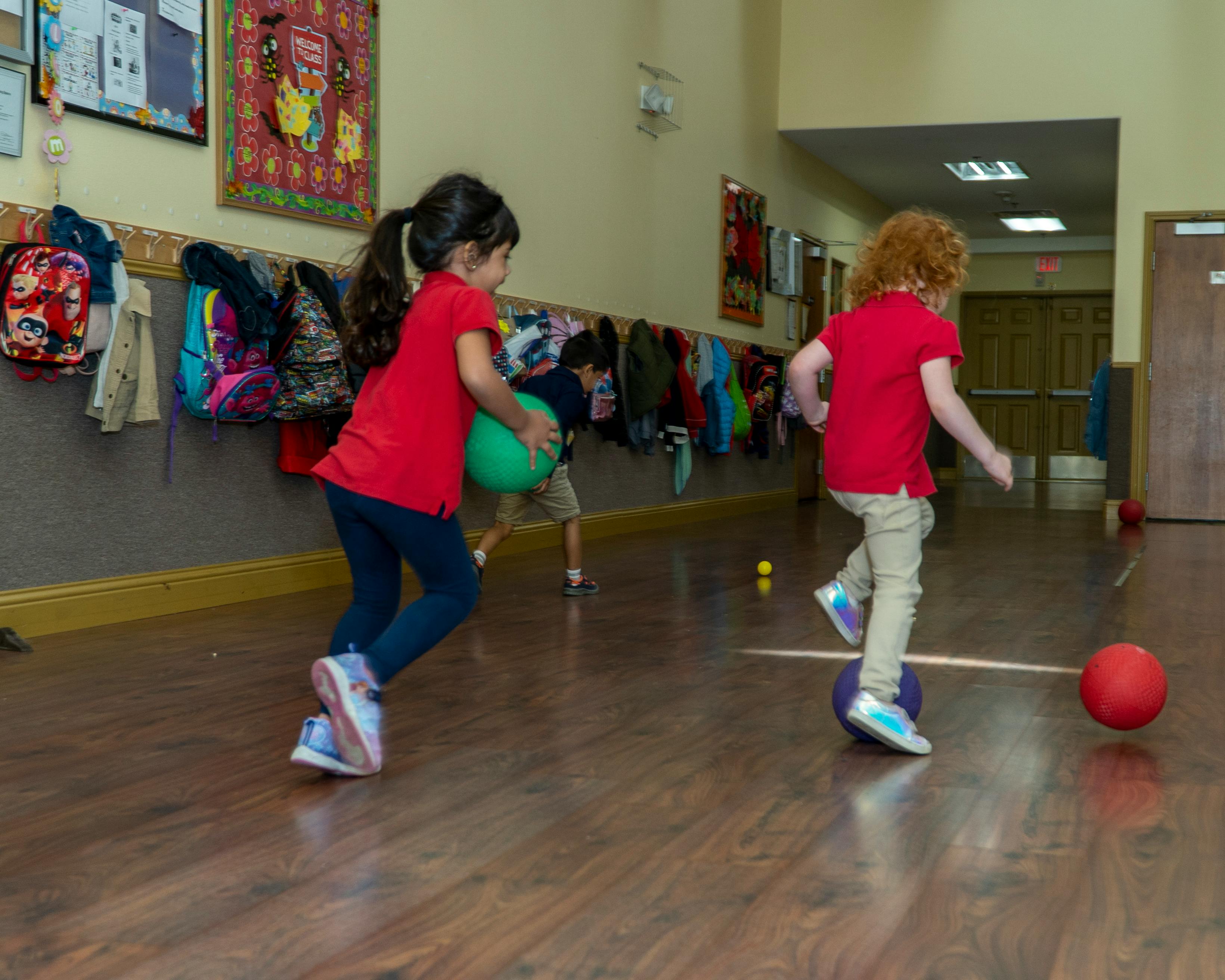 Two children playing with balls indoors