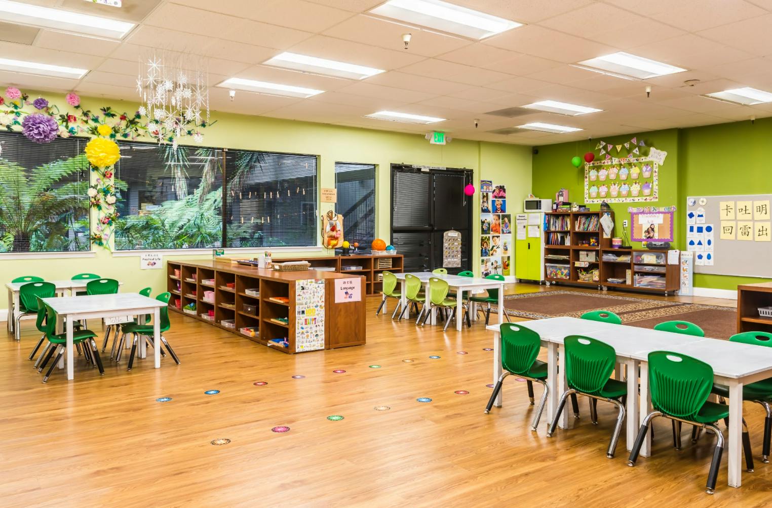 Classroom interior with small tables and chairs arranged on a wooden floor