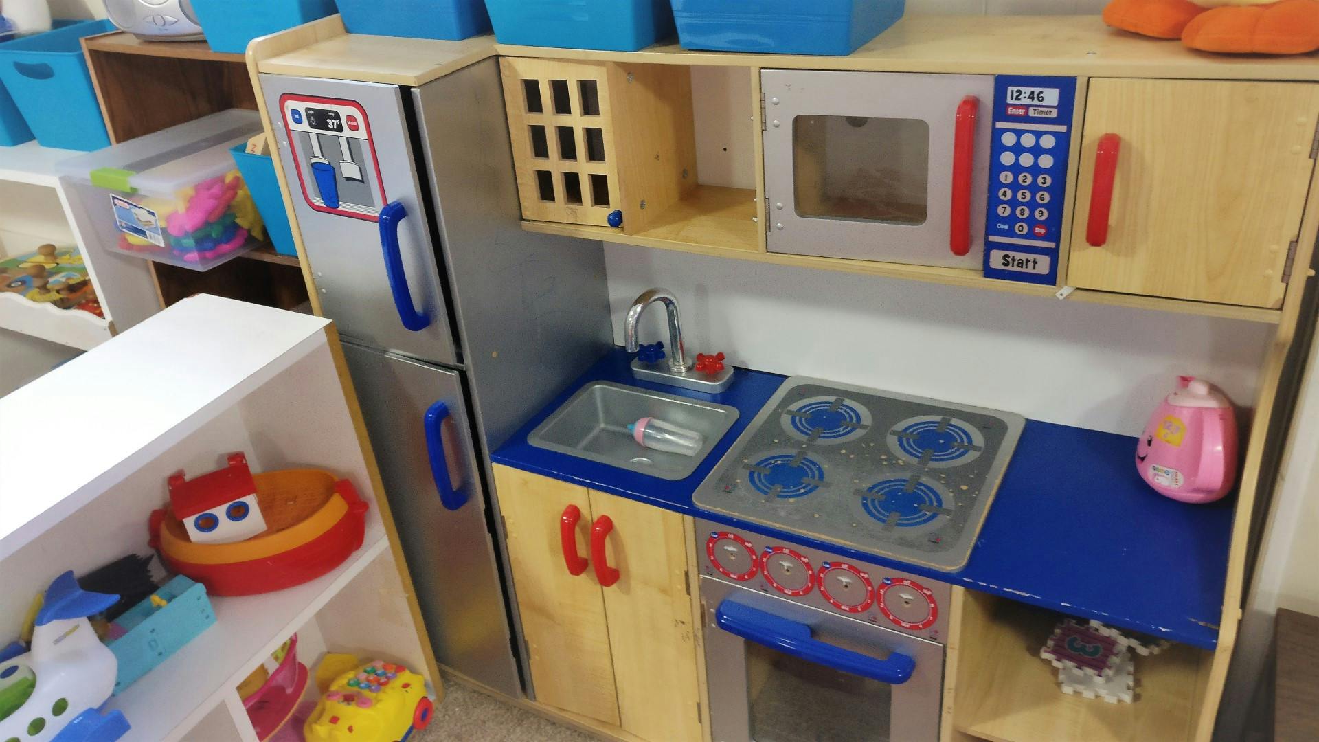 Toy kitchen set with a refrigerator, microwave, sink, and stove