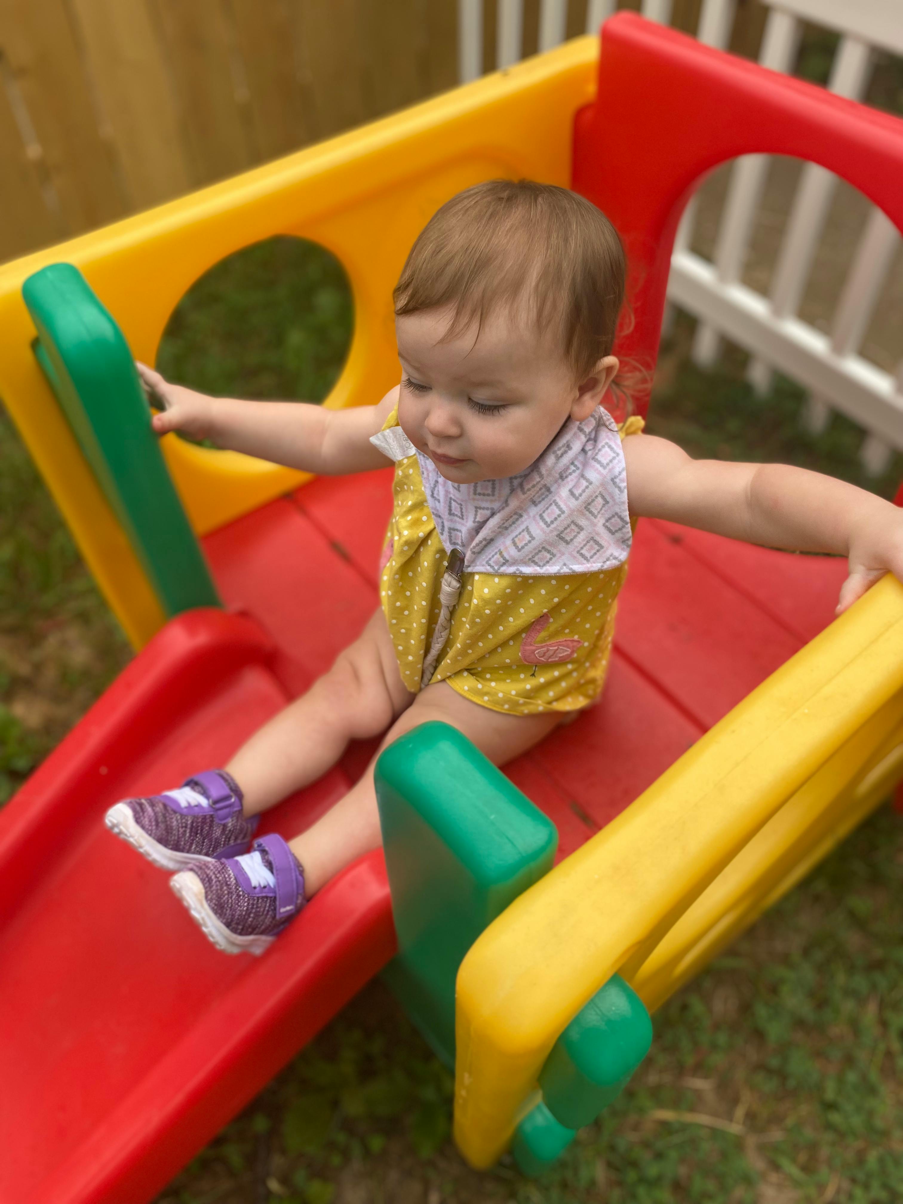 Child sitting on a colorful playground slide