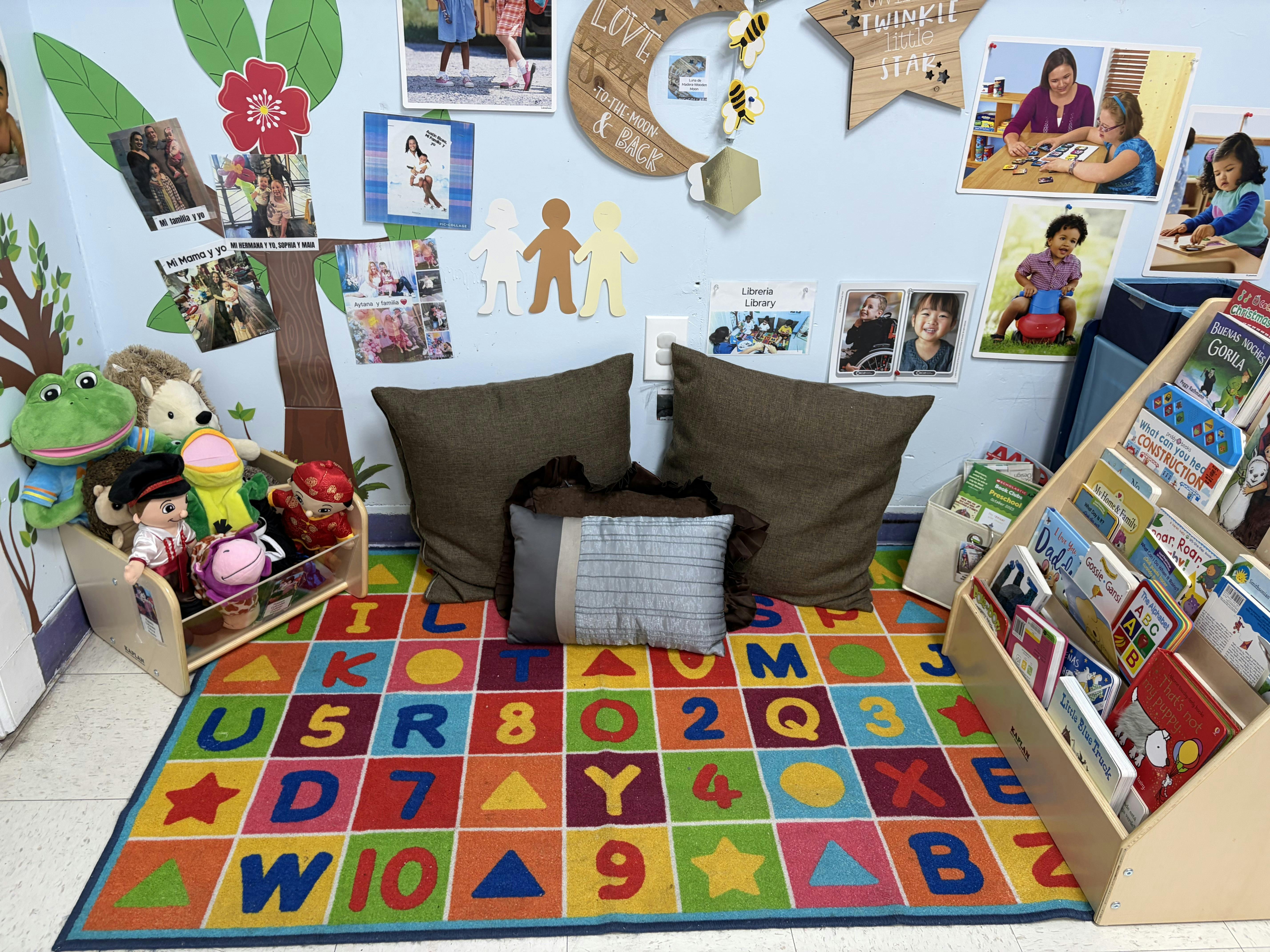 Colorful preschool reading corner with alphabet rug and book bins