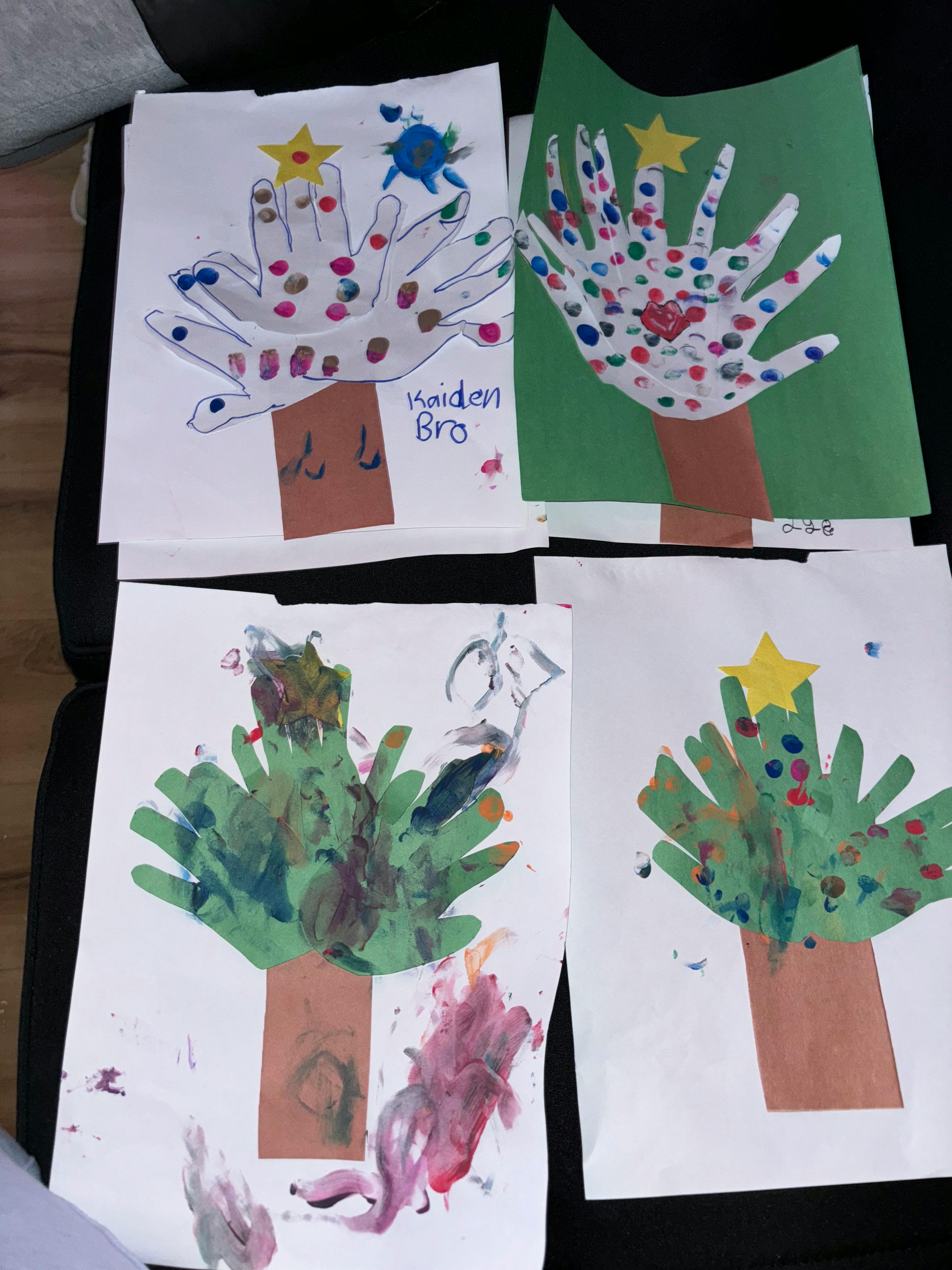 Four pieces of children's artwork depicting handprint trees