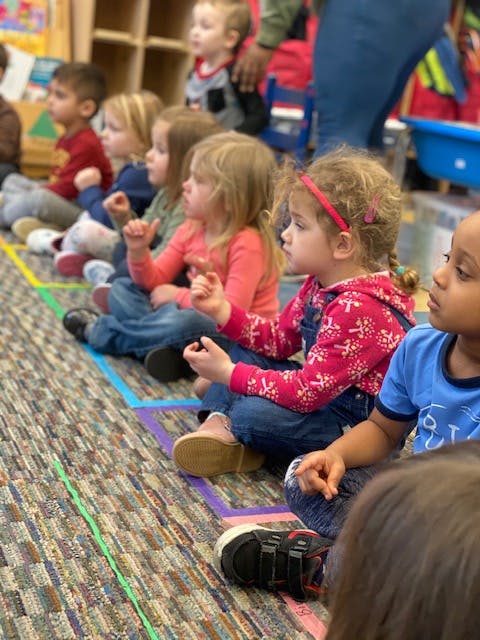 Children sitting on the floor in a classroom