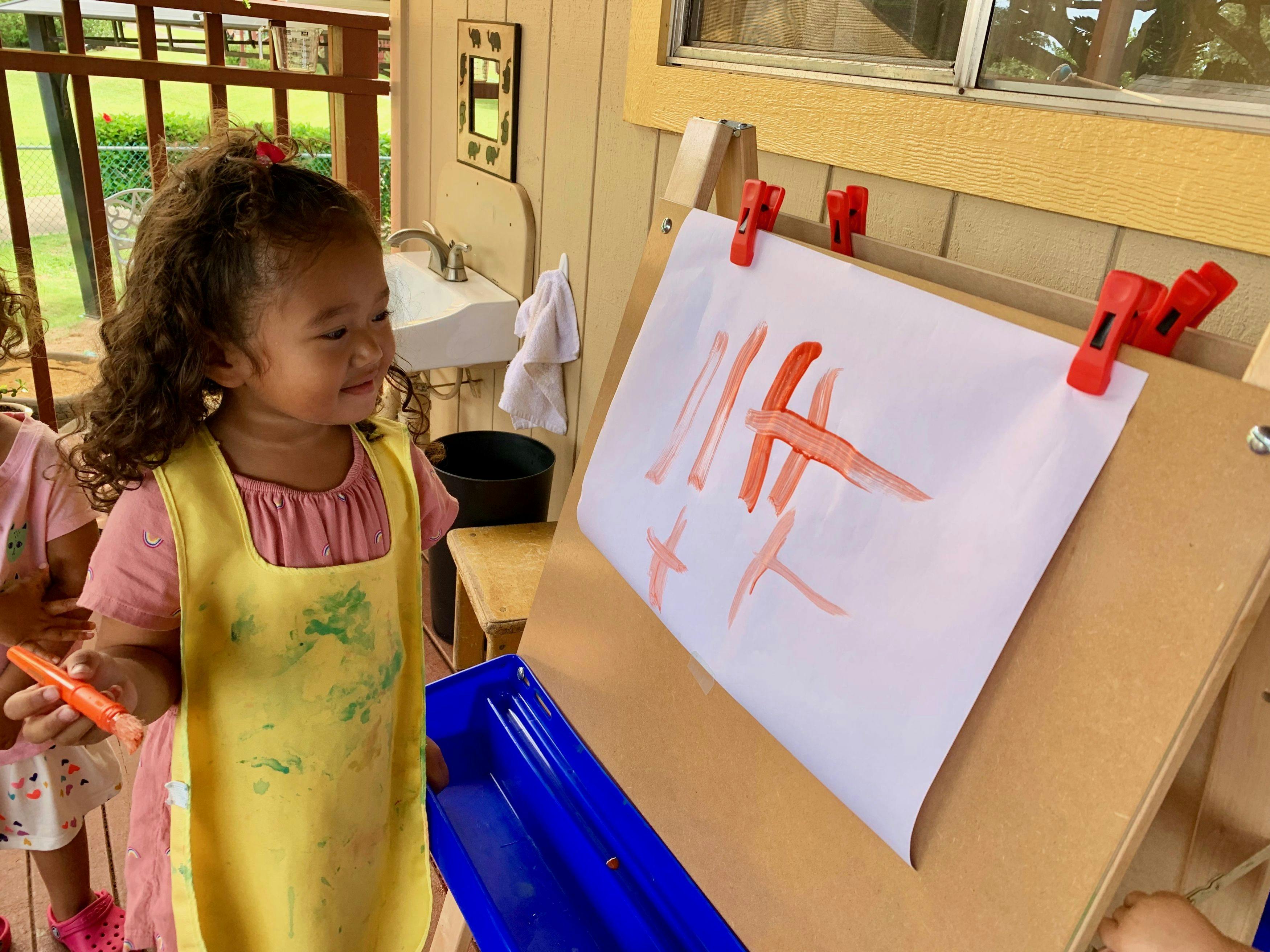 Child painting on an easel