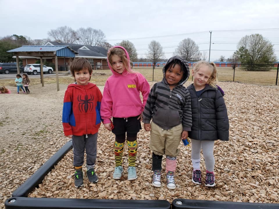 Four children standing on a playground