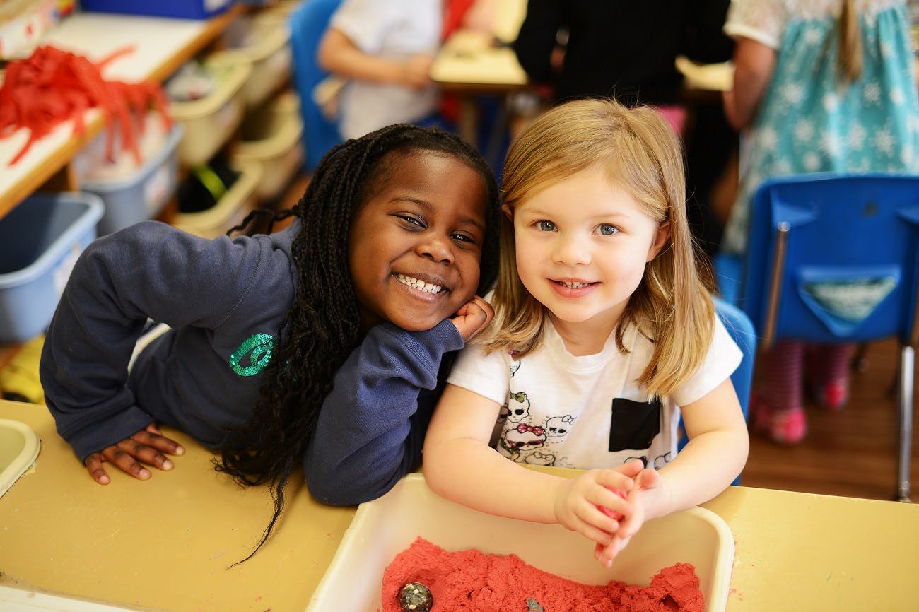 Two children smiling in a classroom