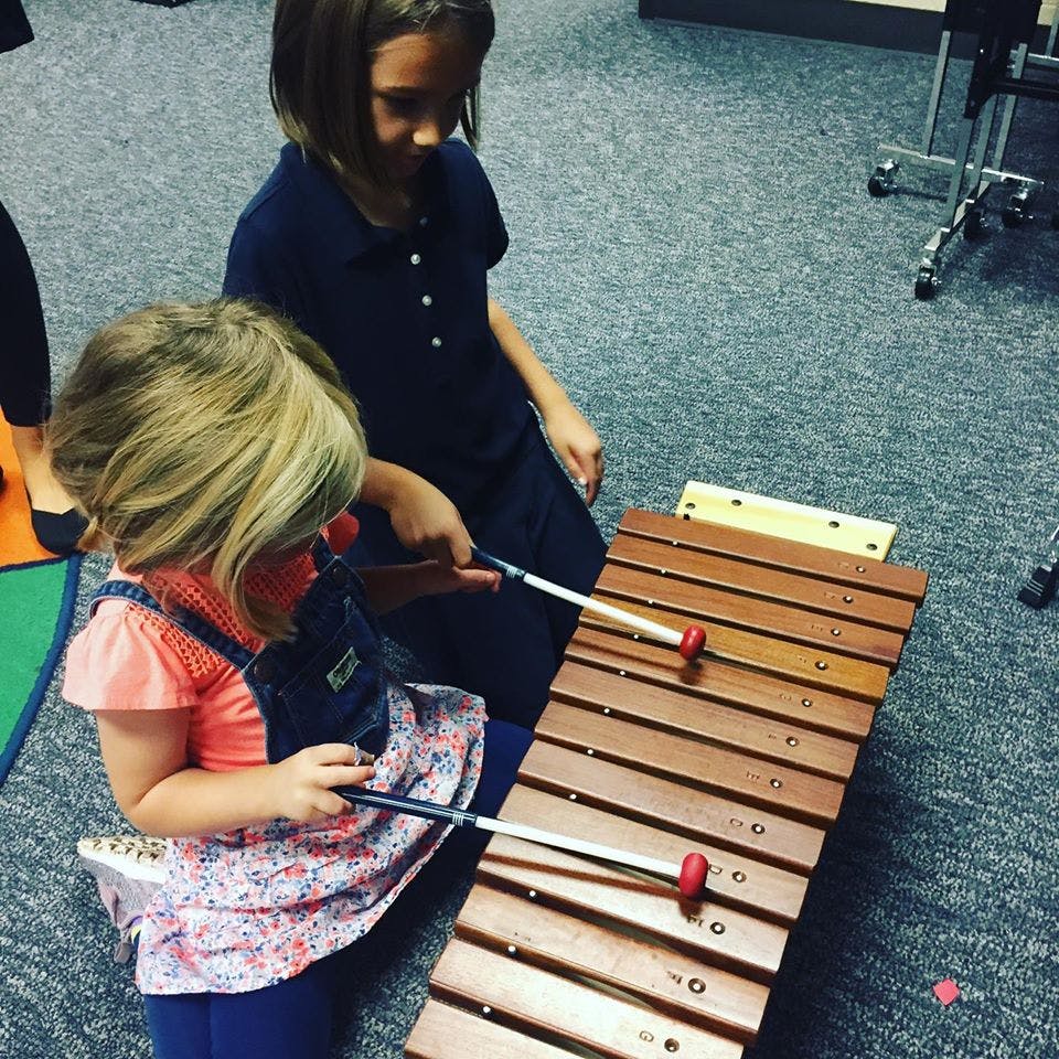 Two children playing a xylophone