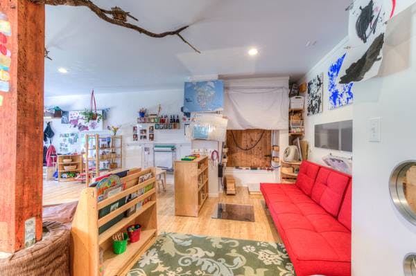 Classroom with red couch, bookshelves, and children's artwork