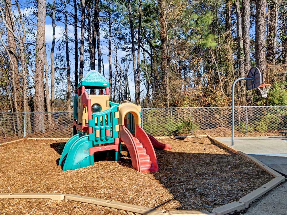 Colorful playground with slides next to a basketball hoop