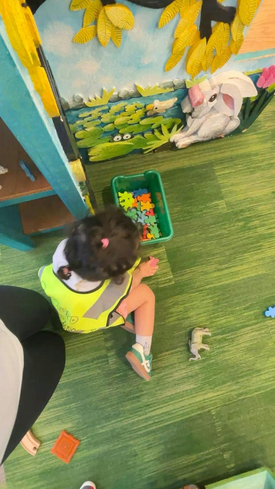 Child playing with small toys on a floor