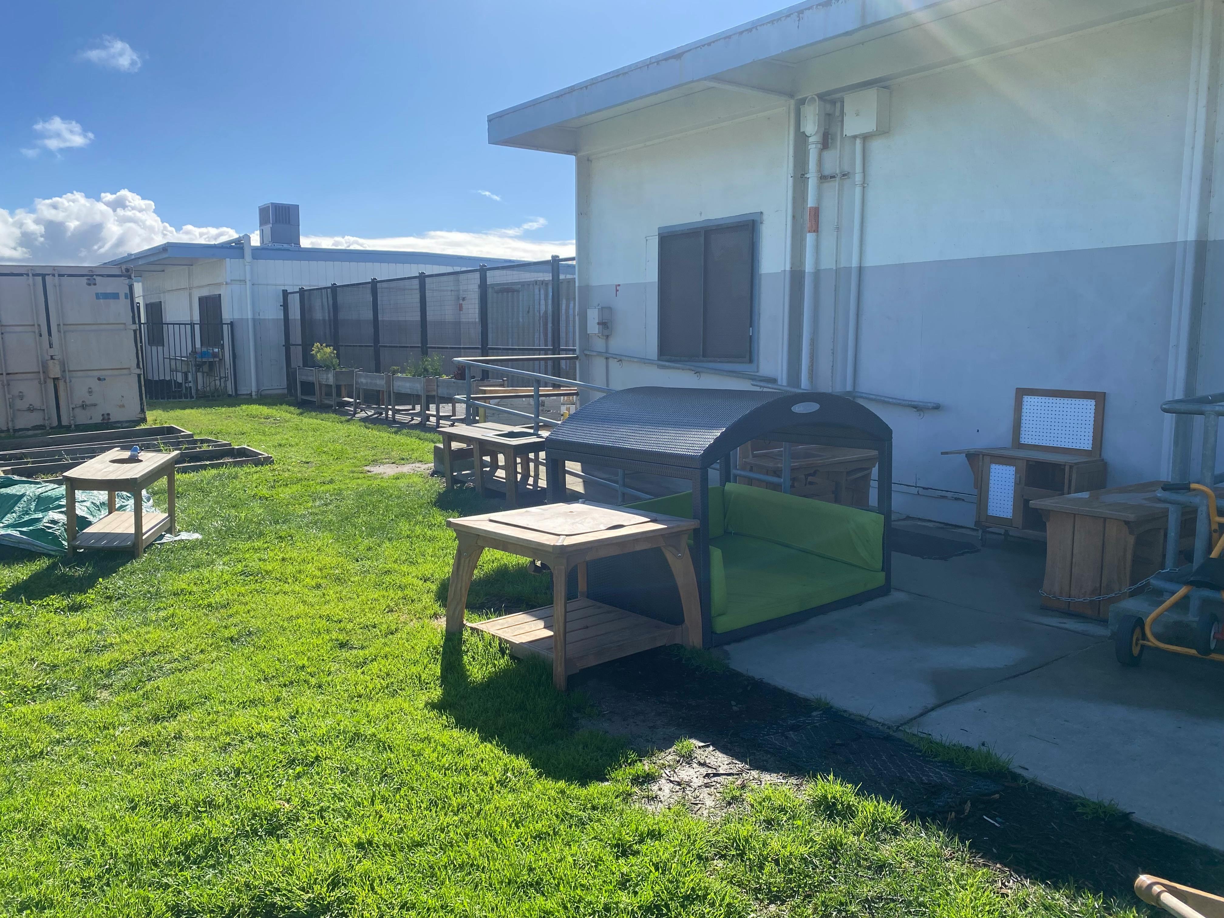 Outdoor area with grass, tables, and a building