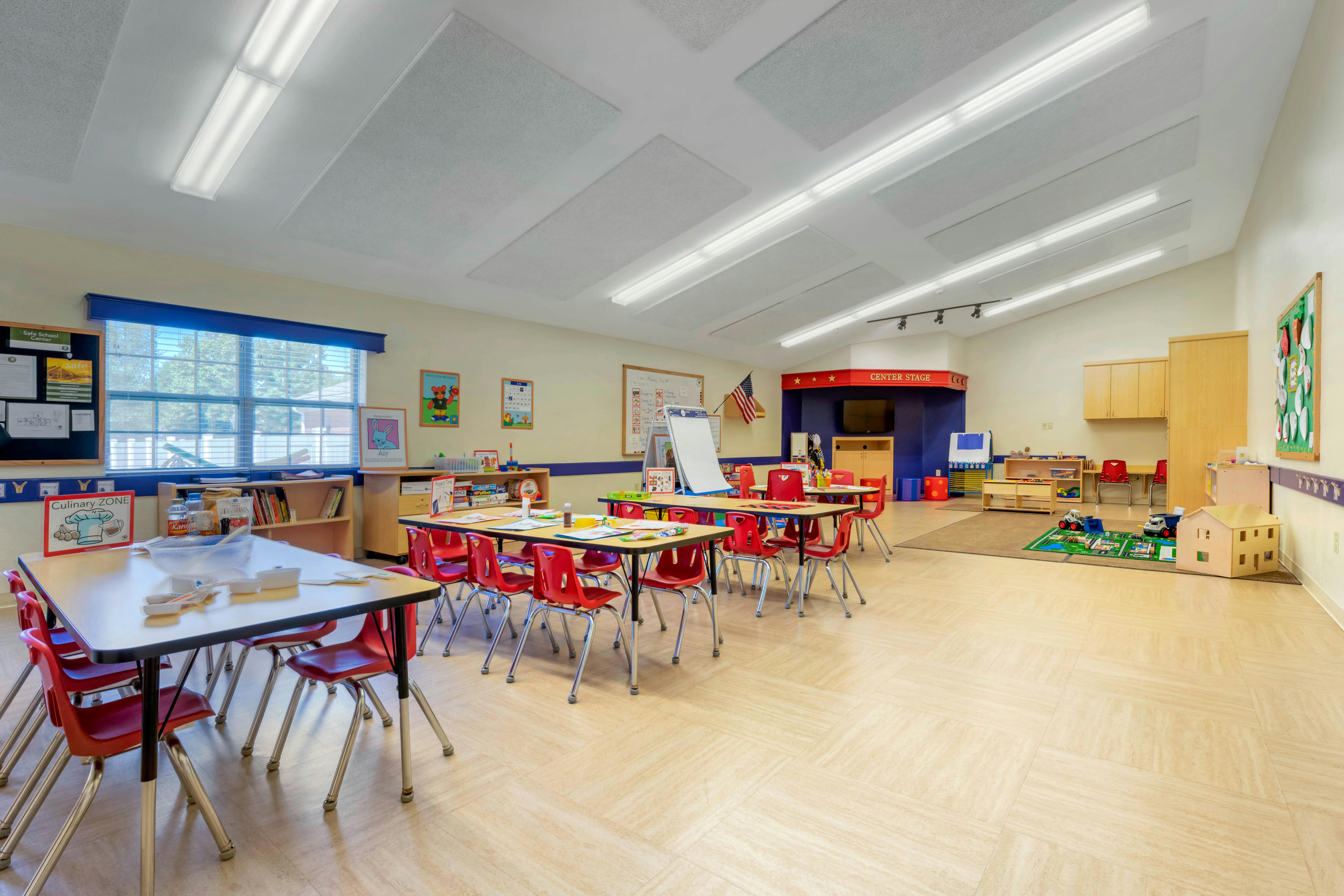 Classroom with child-sized tables and red chairs
