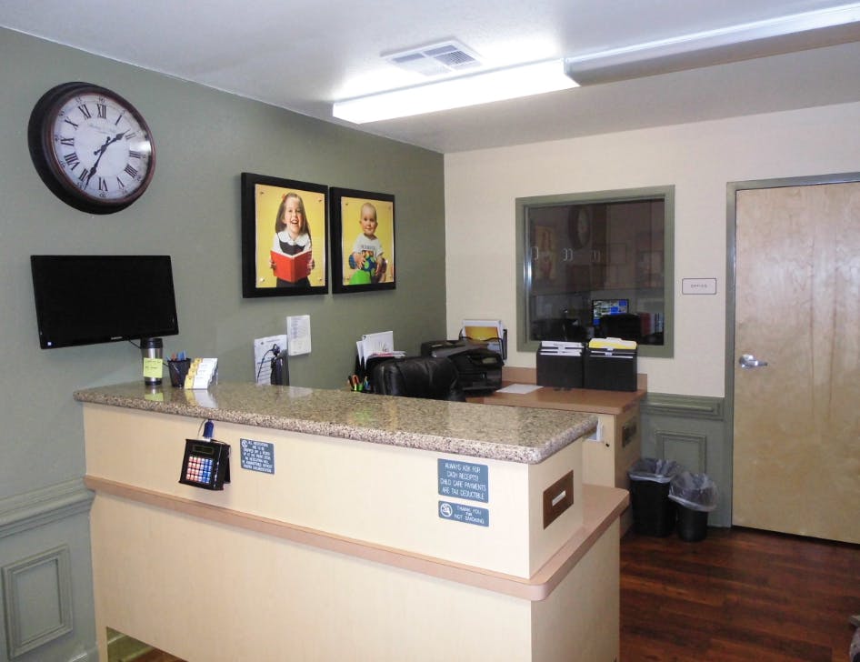 Reception desk with a clock and framed pictures on the wall