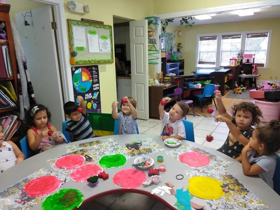 Children at a table with paint and craft supplies