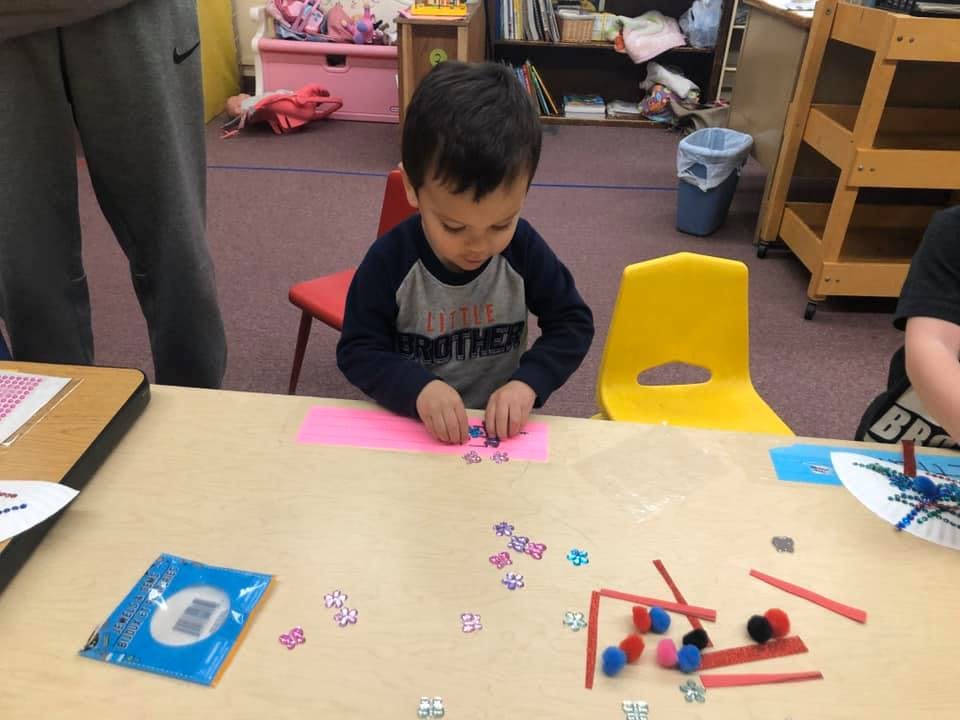 Child working on a craft at a table