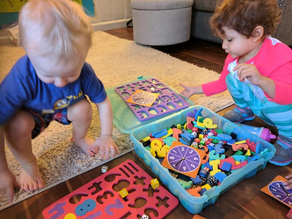 Two children playing with colorful learning toys on the floor
