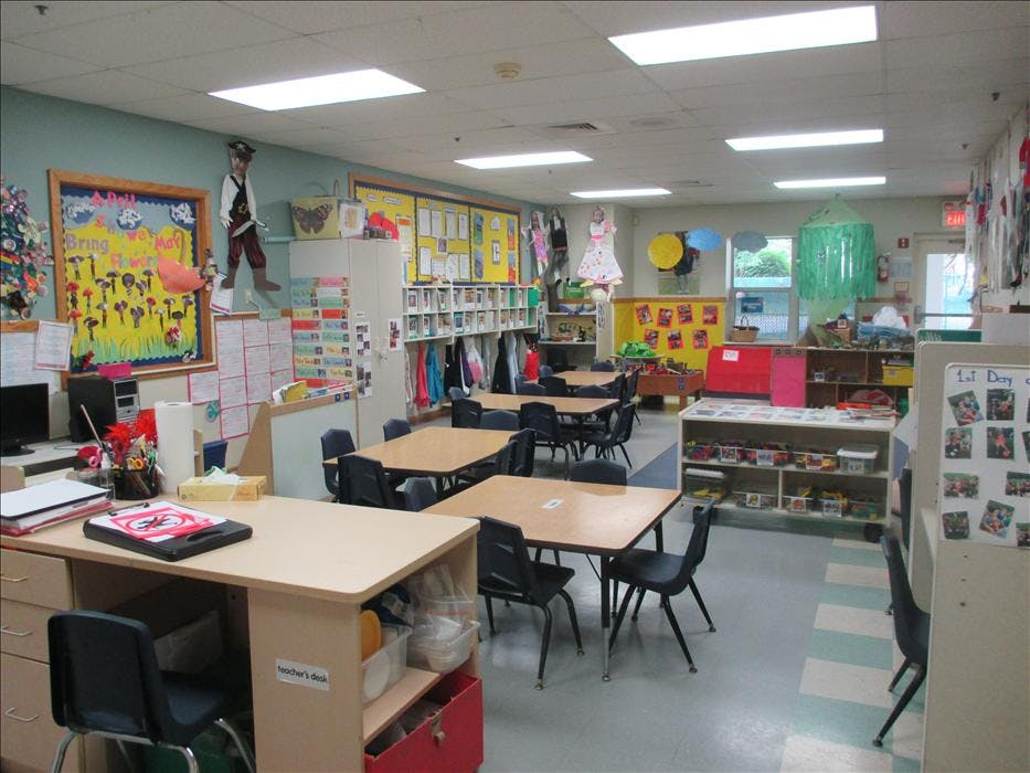 Empty classroom with student desks, chairs, and learning materials