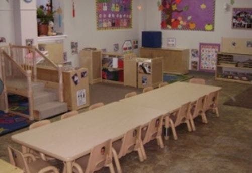 Empty classroom with long table and small chairs