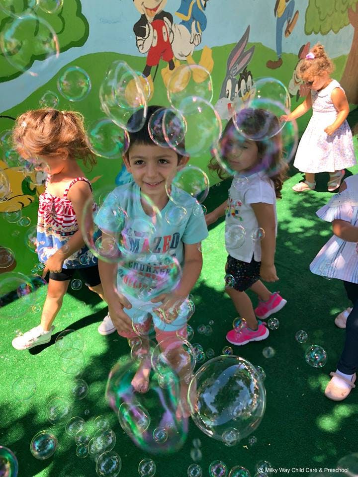 Children playing with bubbles outdoors