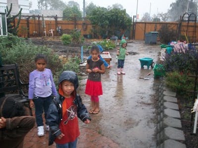 Children standing in a muddy outdoor area