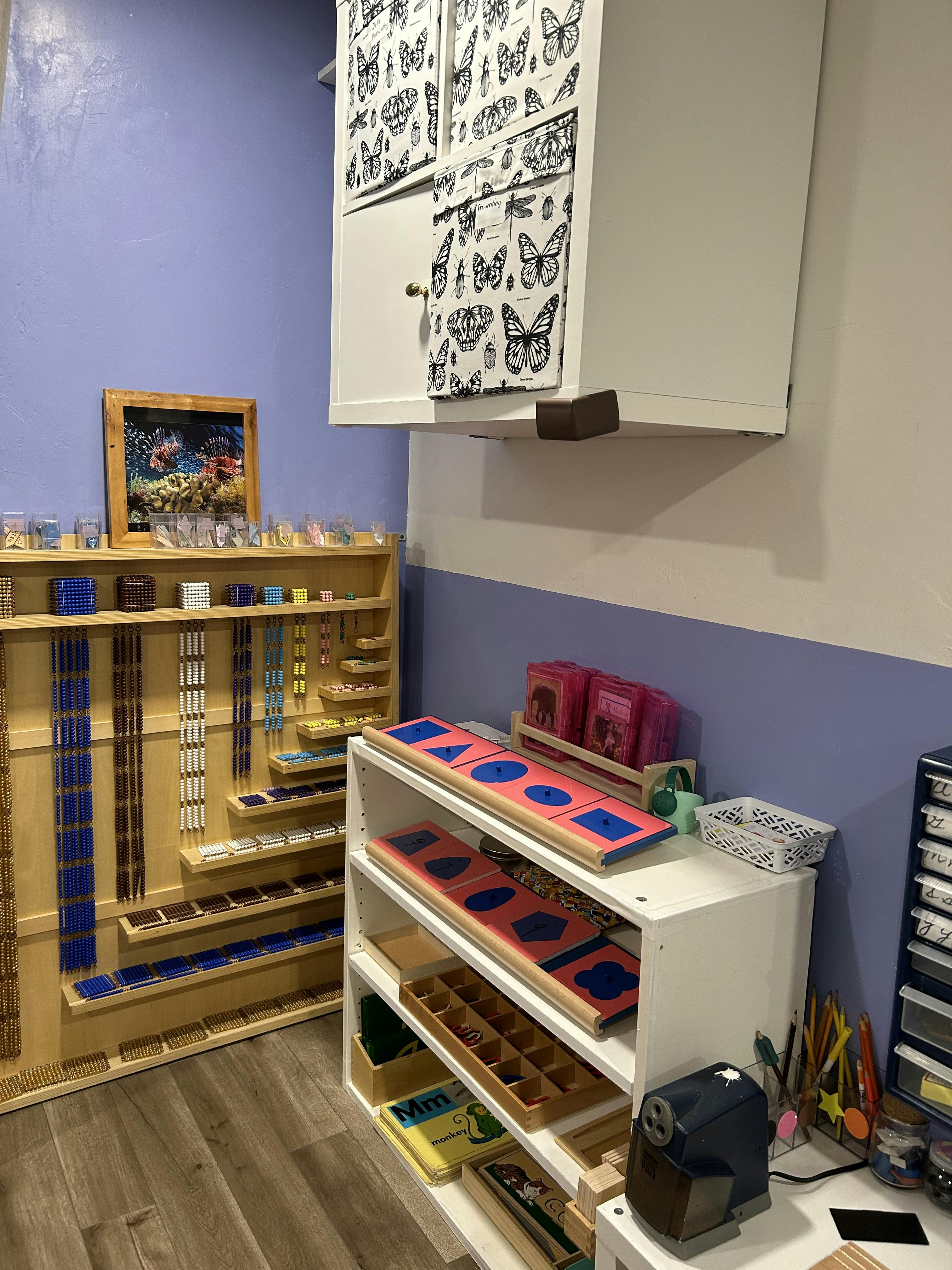 Classroom with shelves of educational materials and a wall-mounted cabinet