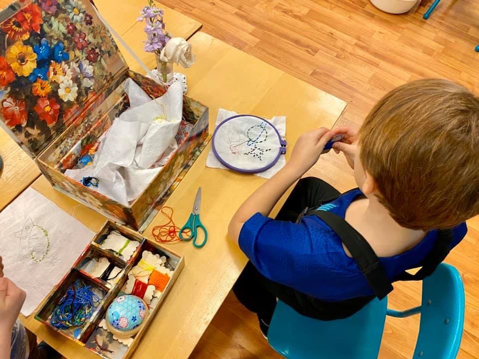 Child doing embroidery at a table