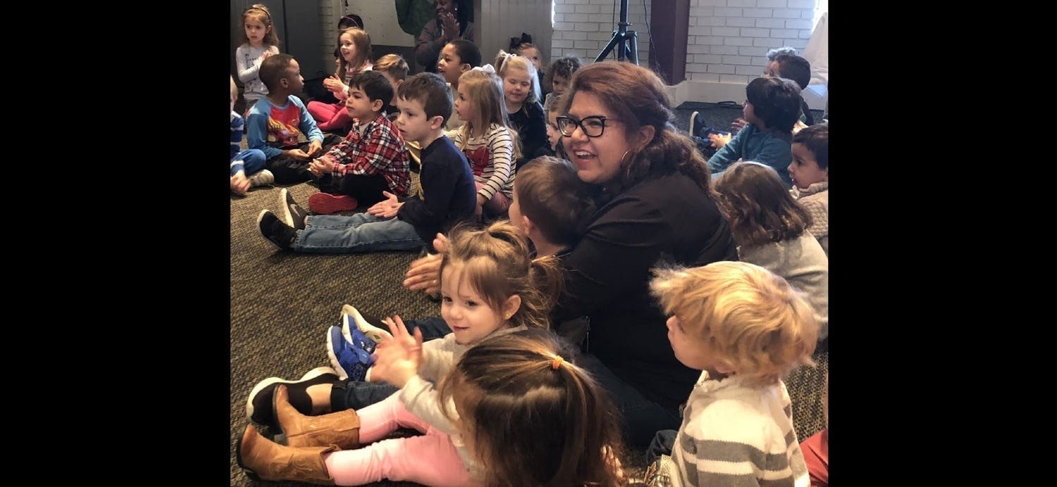 Adult and children sitting on the floor in a group