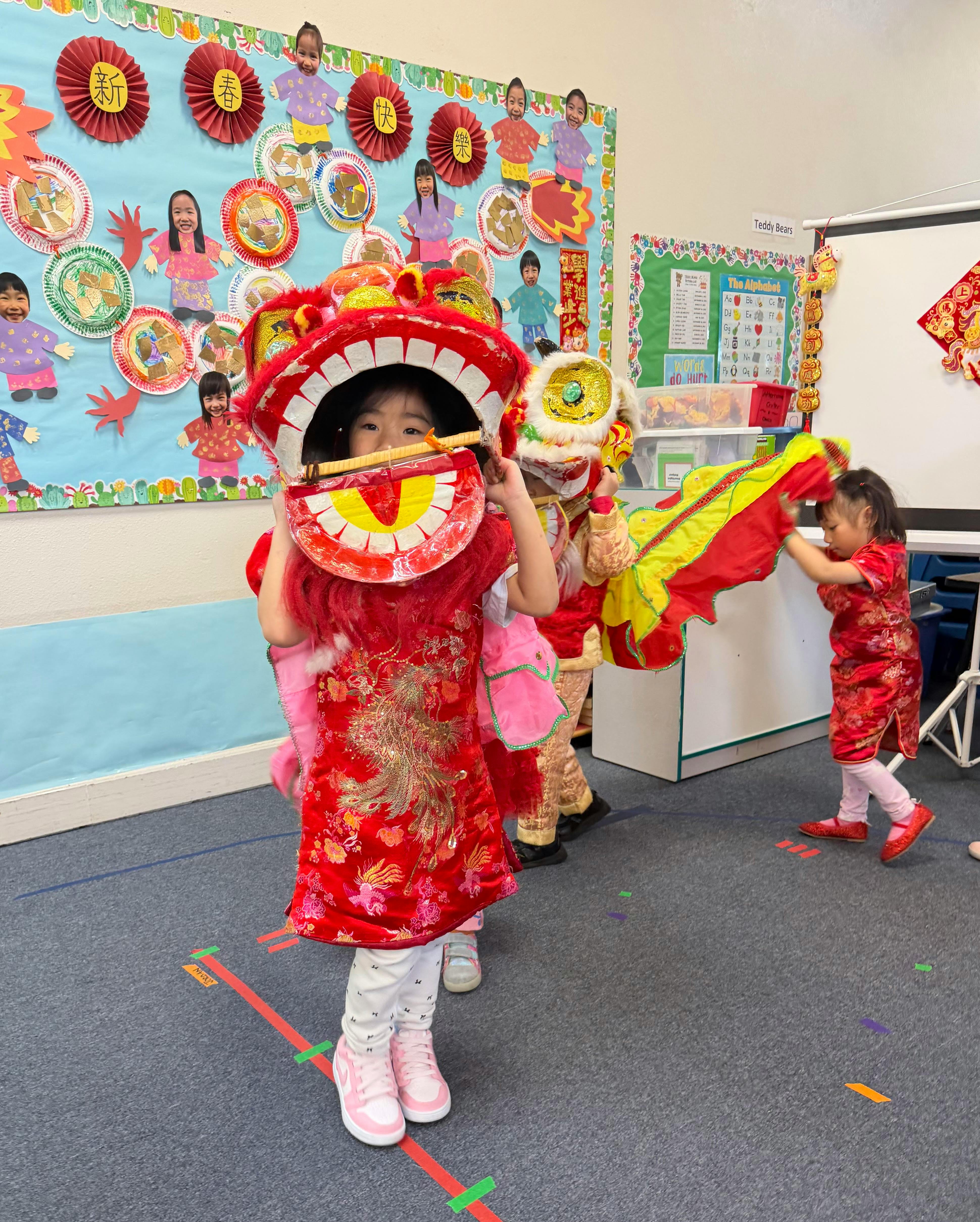 Children performing a traditional lion dance in a classroom