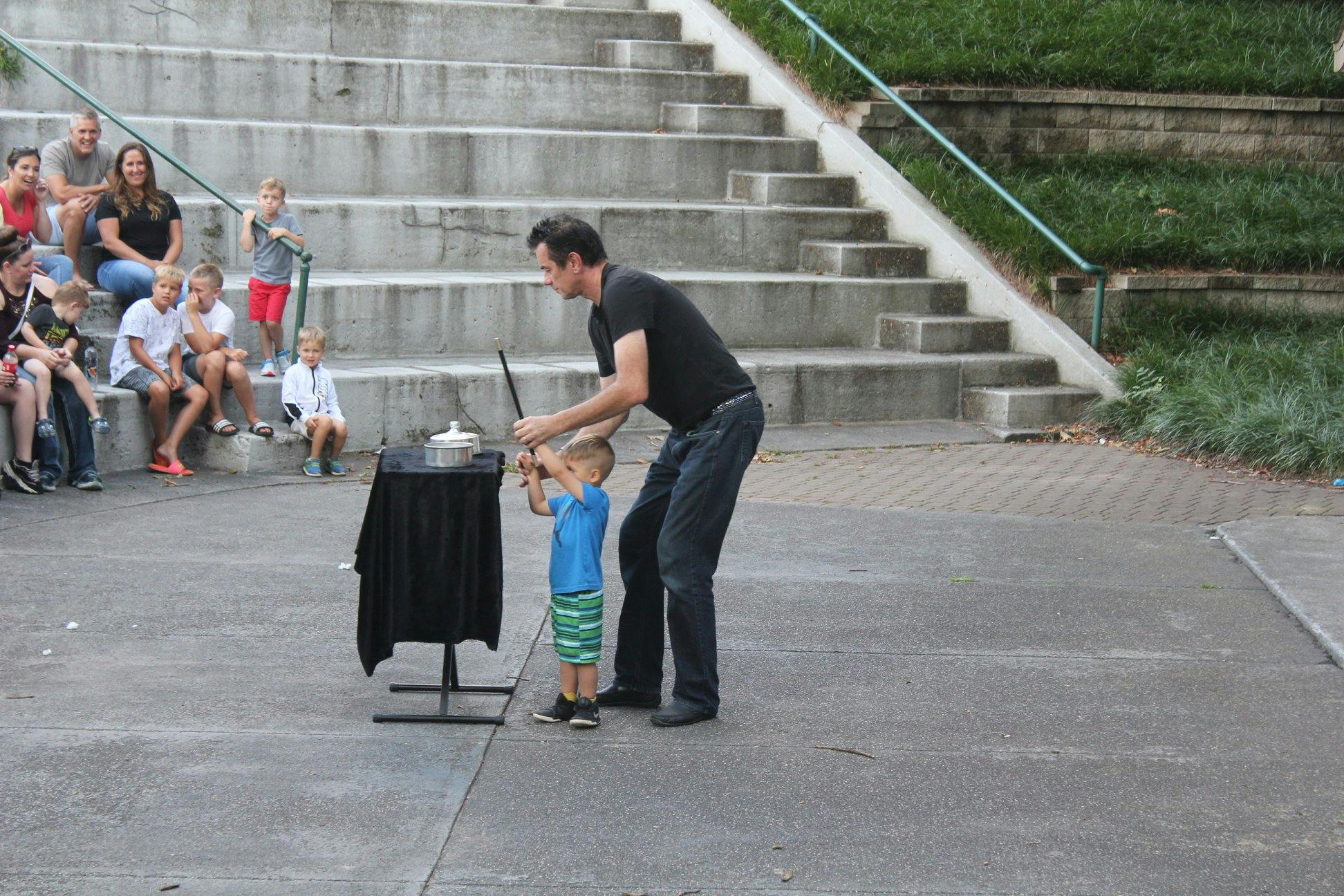 Adult and child performing a magic trick with a wand and table