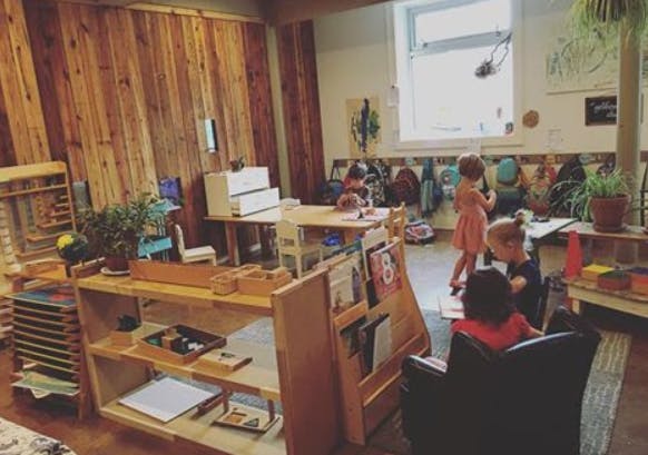 Children in a classroom with wooden furniture and materials