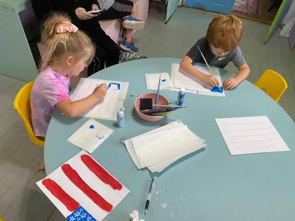 Two children painting at a table