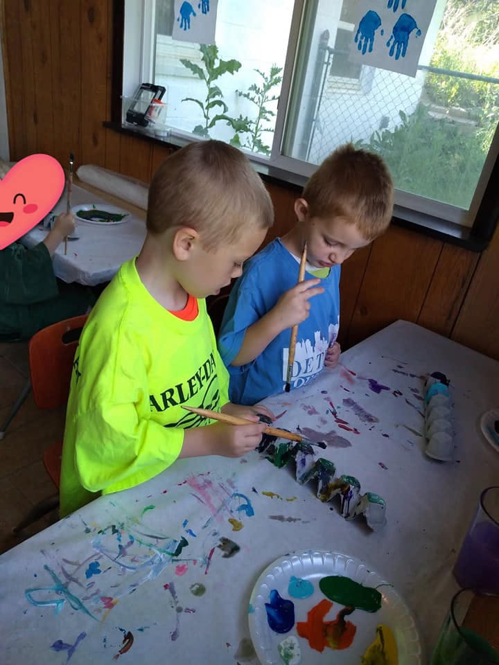 Two children painting at a table