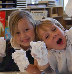 Two children with shaving cream on their hands