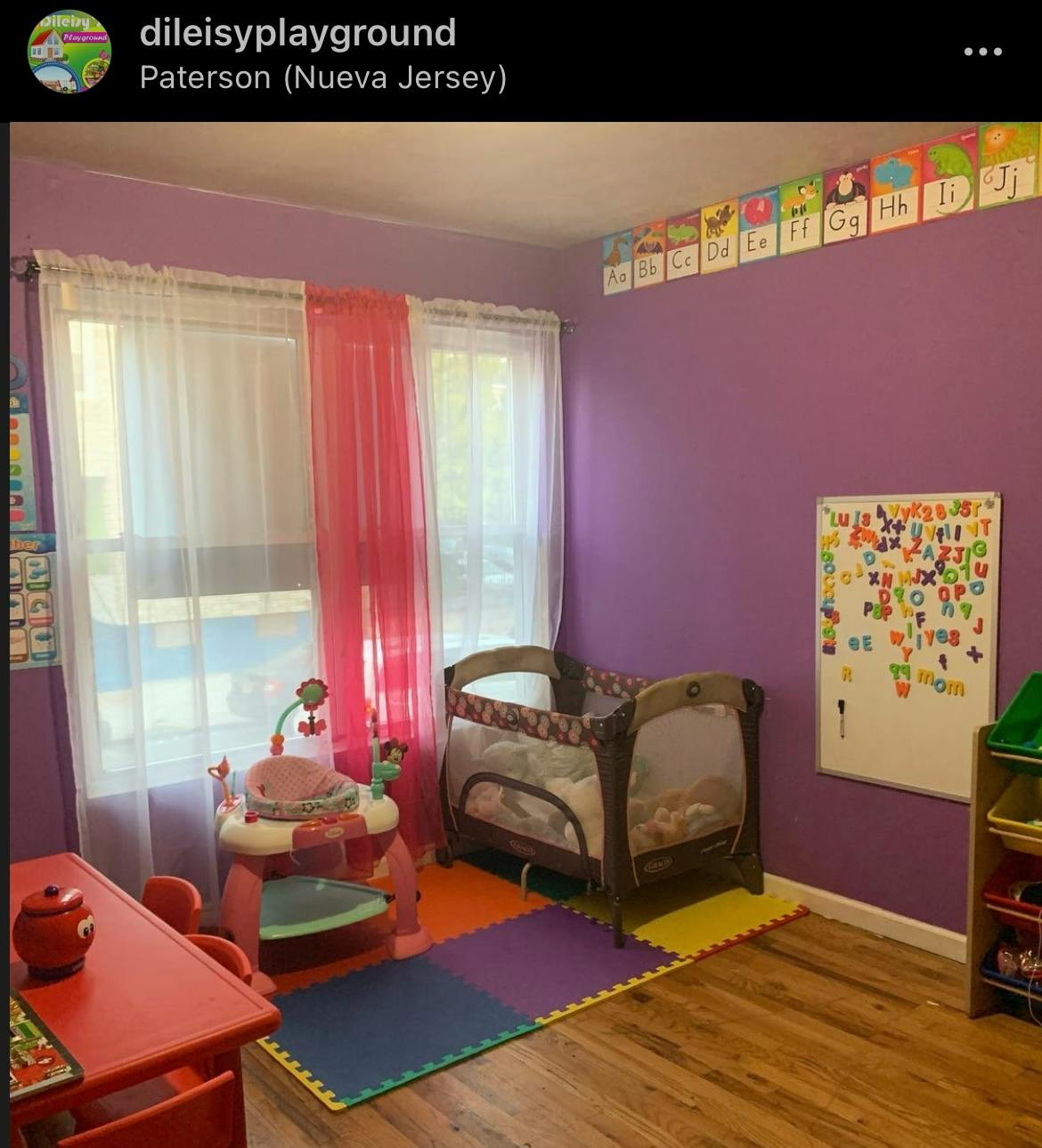 Nursery room with a crib, play mat, and small table