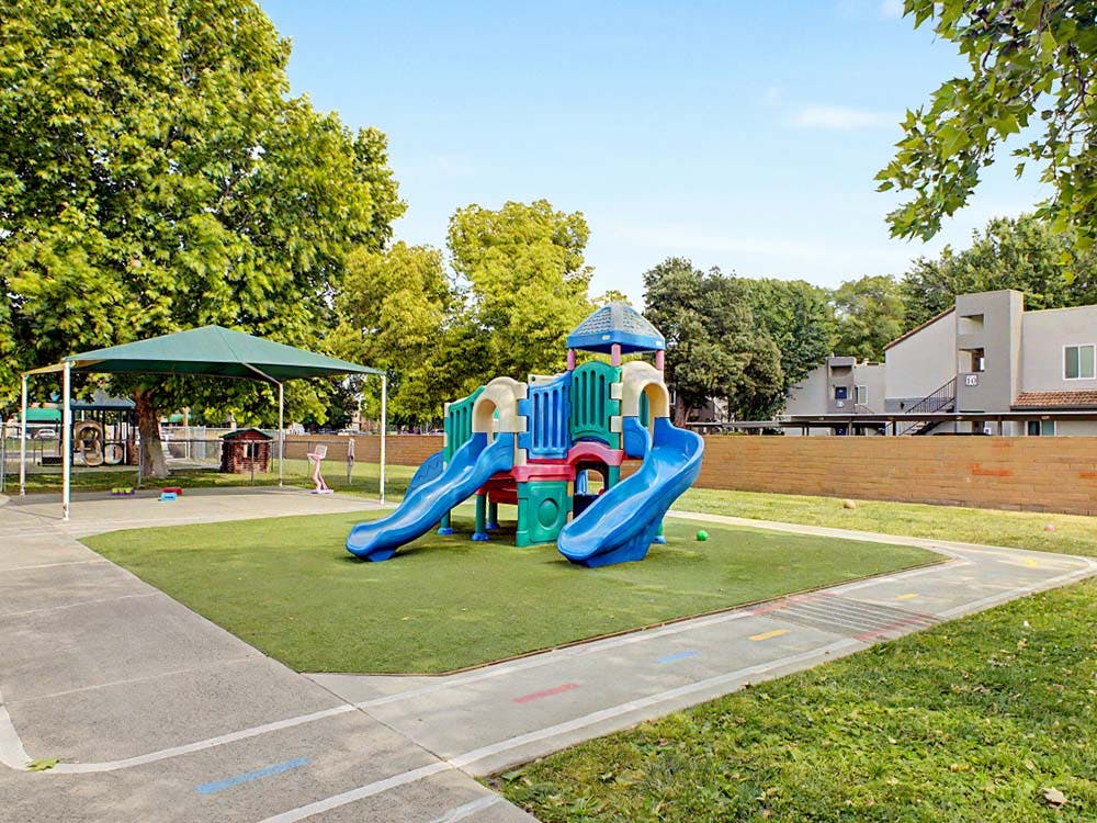Colorful playground with two slides on artificial turf