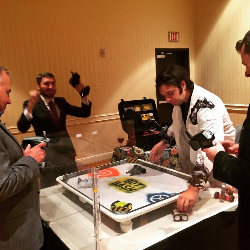 People playing with remote control cars on a game board