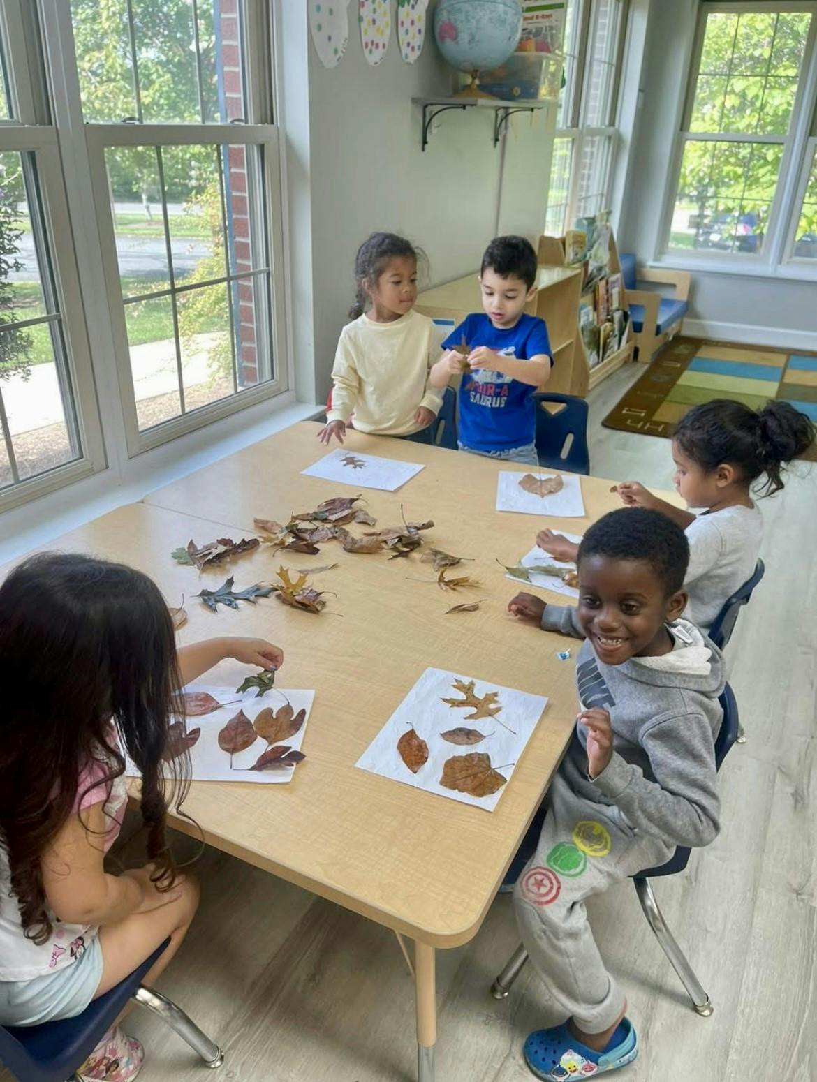 Children at a table doing an activity with leaves