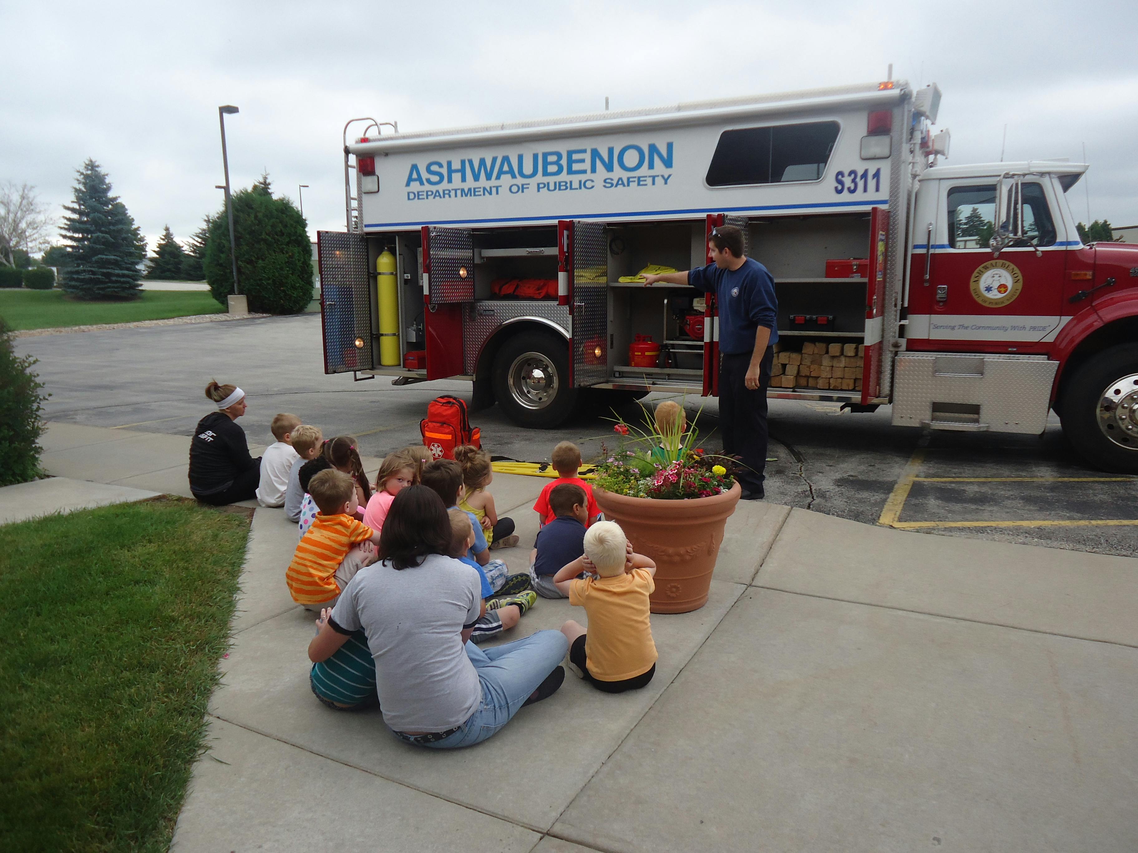Person showing children equipment from a fire truck