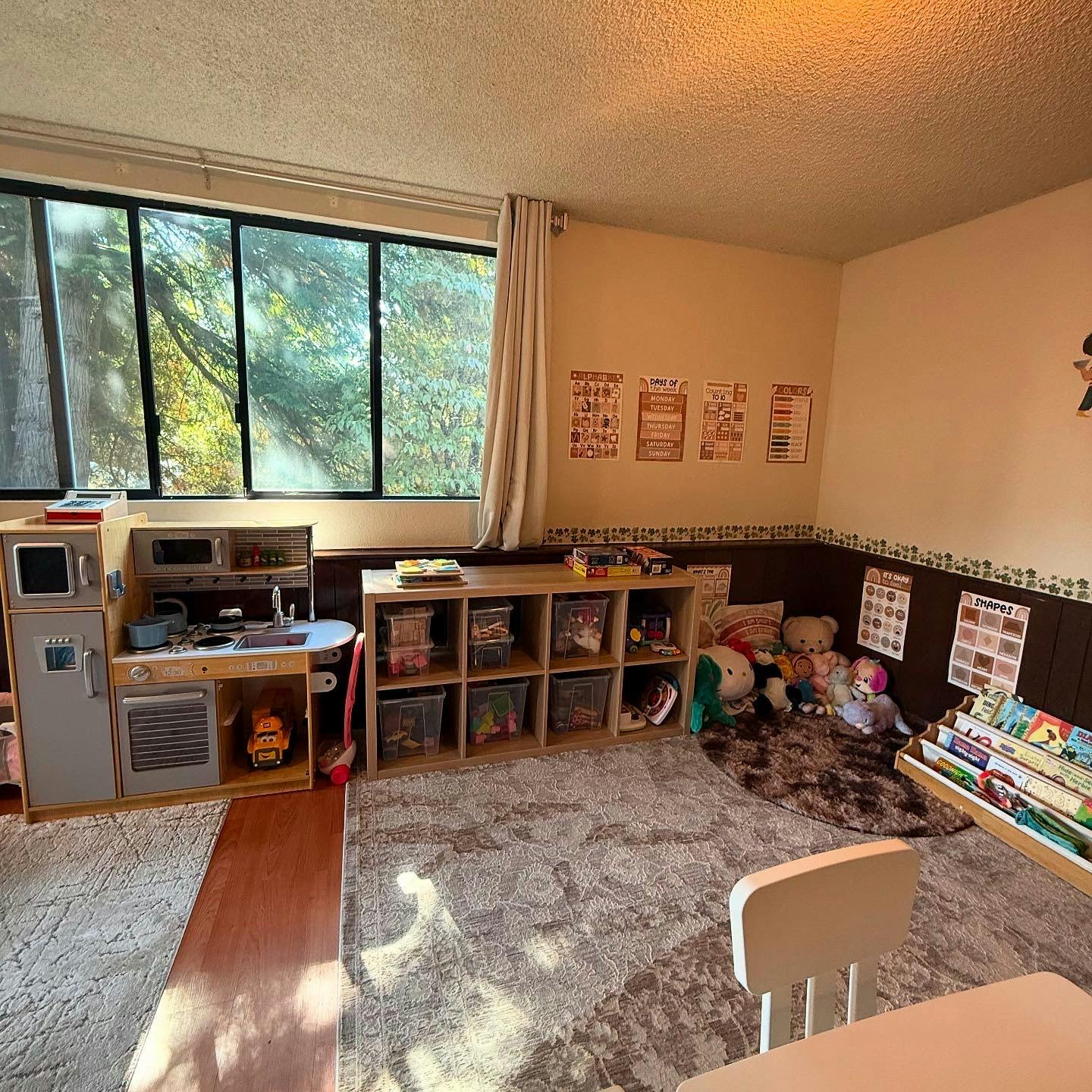 Playroom with toy kitchen, storage shelves, and window