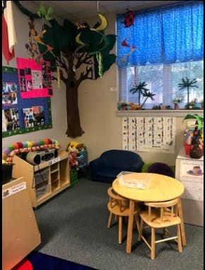 Children's play area with a small table and chairs, tree decoration, and window