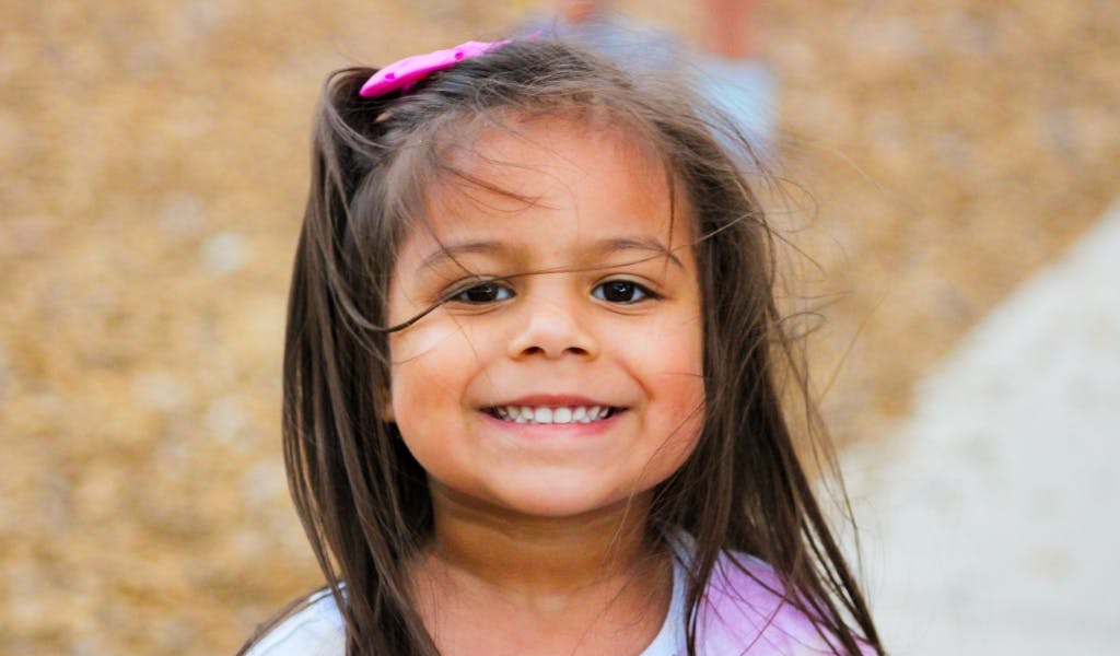 Child with long hair smiling