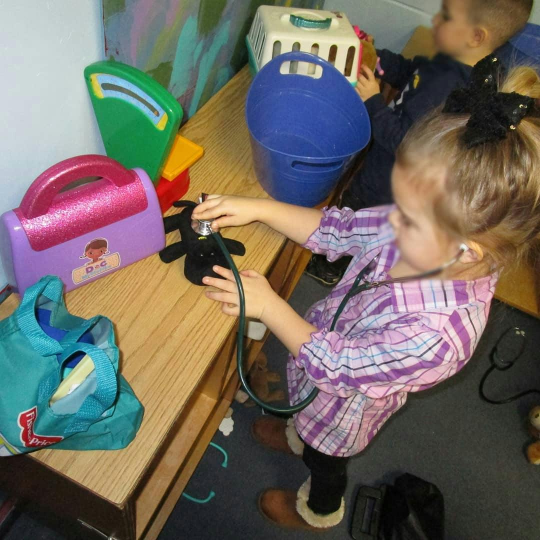 Child playing with a toy stethoscope and other toys