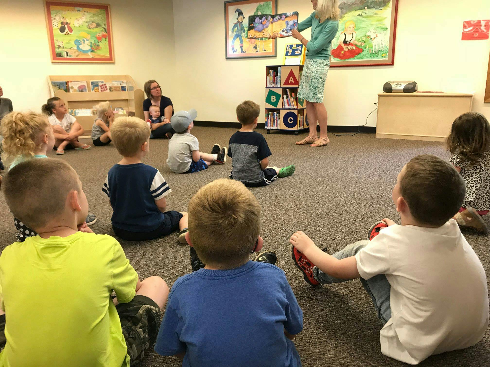 Adult reading to children sitting on the floor in a classroom