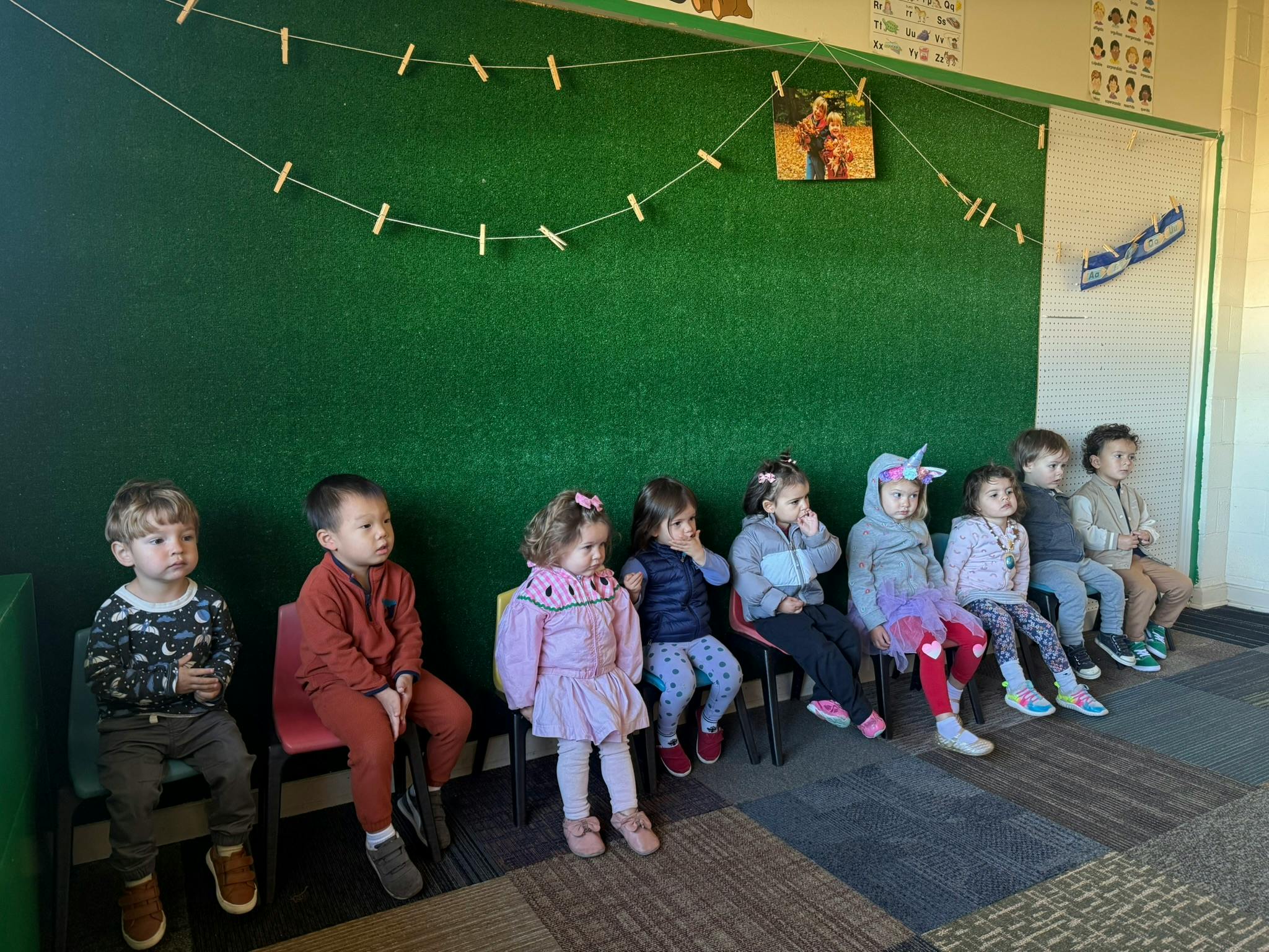 Group of children sitting in chairs in a classroom