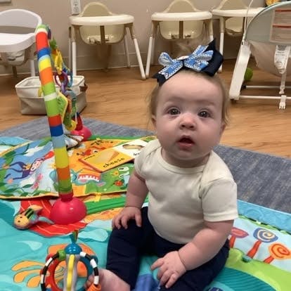 Child sitting on a playmat with toys