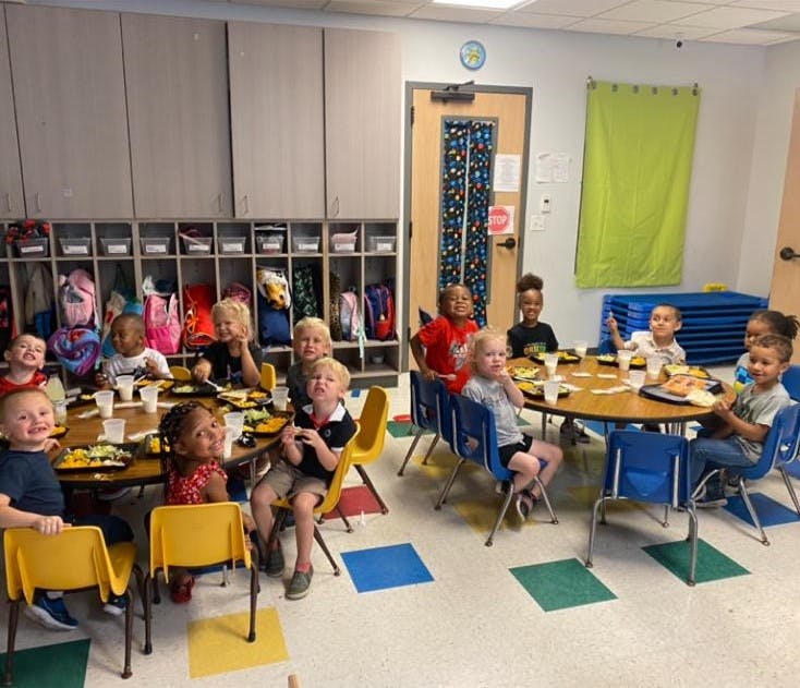 Children sitting at tables in a classroom