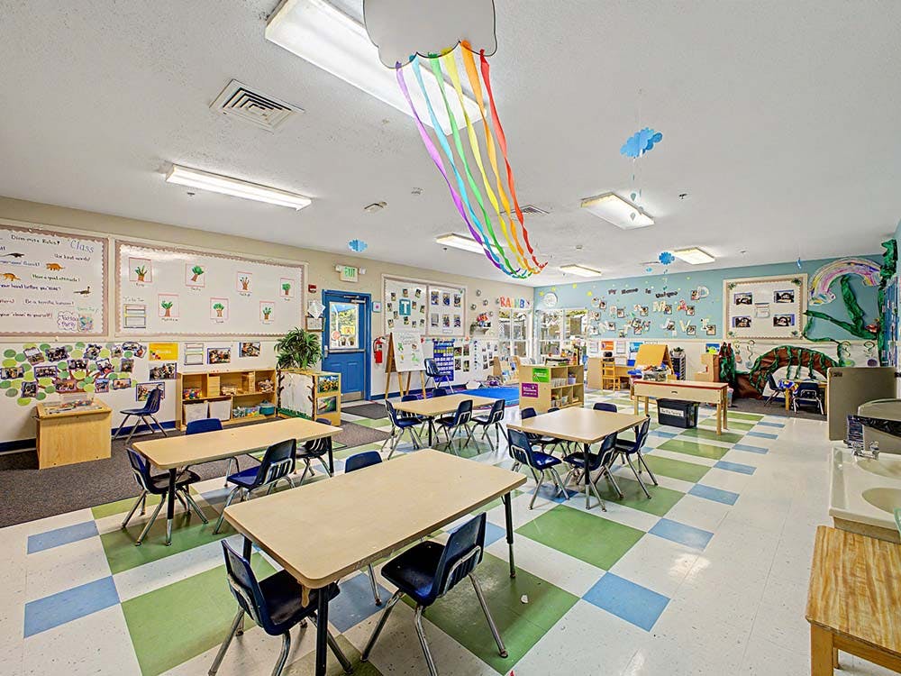 Empty colorful classroom with small tables and chairs